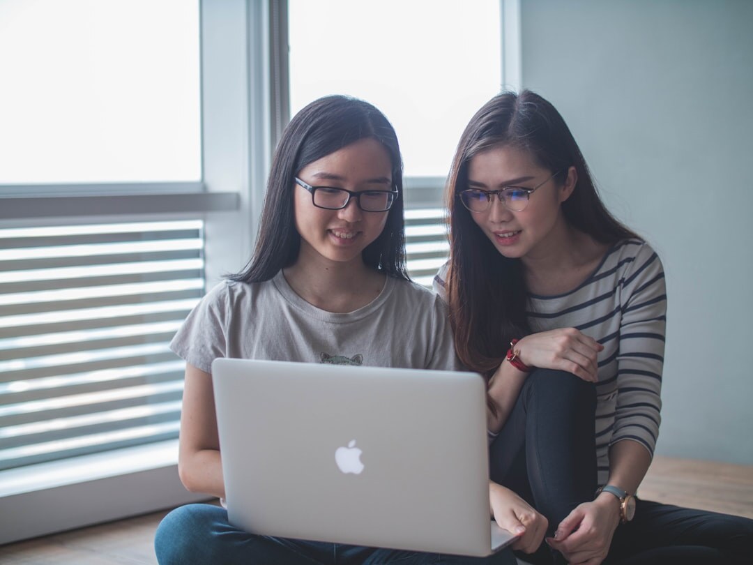 Two editors reviewing a layout together on a laptop
