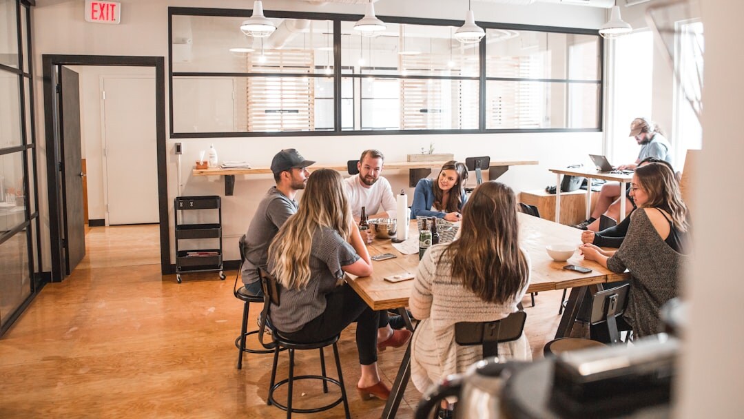 Editorial team discussing stories around a table in a modern newsroom