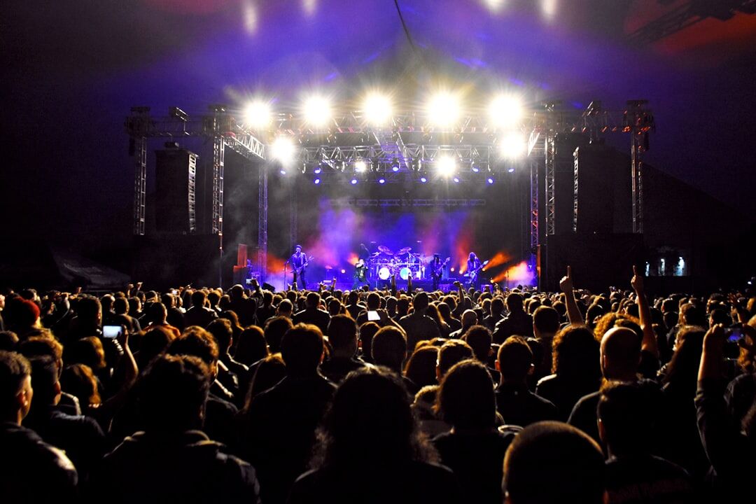 Concert stage with bright colorful spotlights and a performing crowd