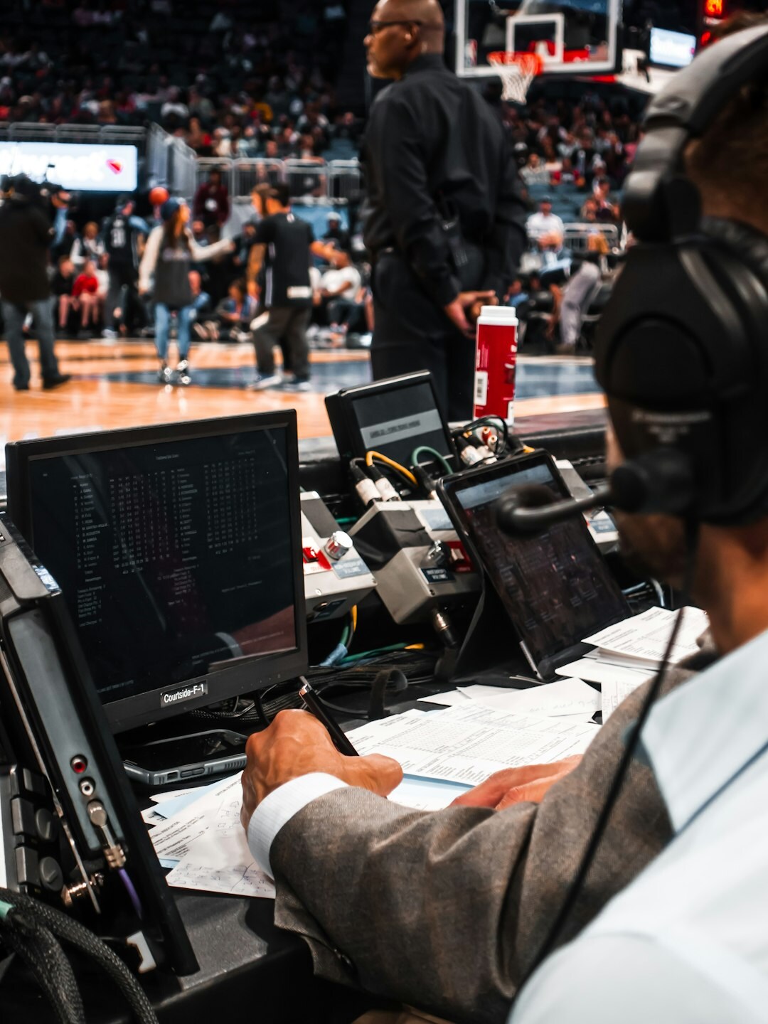 Journalist writing notes while watching a television broadcast